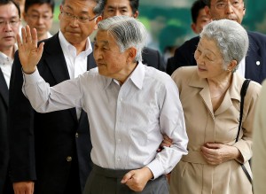 Japan's Emperor Akihito, flanked by Empress Michiko, waves to well-wishers as they board a Shinkansen bullet train to depart to their imperial summer villa in Nasu, at Tokyo station in Tokyo
