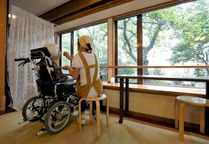 A carer feeds a resident on a wheelchair at the private nursing home "Silver Villa Koyama" in Tokyo